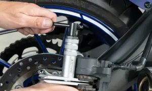 Narzędzie do ściskania tłoczków w zacisku hamulcowym motocykla, ułatwiające wymianę klocków hamulcowych.