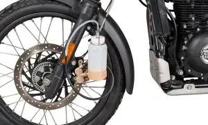 Zbiorniczek z płynem do odpowietrzania hamulców motocykla, podłączony do zacisku hamulcowego przy przednim kole.