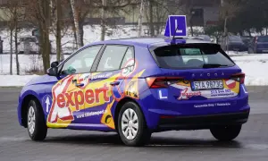 Niebieski samochód szkoleniowy z napisem "expert" i literą "L" na dachu. Zapytaj, ile trwa kurs na prawo jazdy kat A.