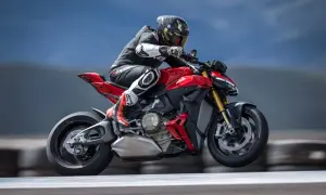 Motocyklista w kombinezonie pędzi na czerwonym Ducati Streetfighter V2, unosząc się lekko nad torem.