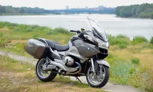 Szary motocykl BMW R 1200 RT z kuframi, gotowy na podróż. Wady i zalety tego modelu są dyskutowane przez pasjonatów.