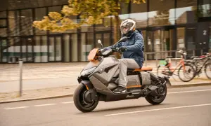 Mężczyzna w kasku jedzie na futurystycznym skuterze BMW CE04.