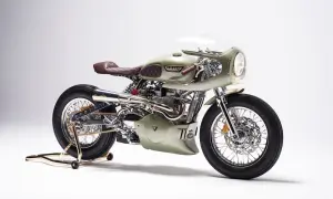 Stuning custom Triumph Thruxton 900 w kolorze oliwkowym, z brązową, pikowaną kanapą i chromowanymi detalami.