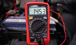 Multimetr pokazuje 14.53V, co jest kluczowe, jak sprawdzić alternator w motocyklu. Pomiar napięcia akumulatora podczas pracy silnika.