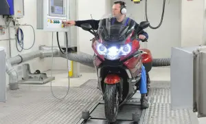 Mechanik sprawdza motocykl na hamowni. Regularny przegląd motocykla 125 zapewnia jego sprawność.