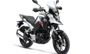 Biały motocykl turystyczny z niebieskimi i czerwonymi akcentami. Od ilu lat można robić prawo jazdy na motor 125? Od 16 roku życia.