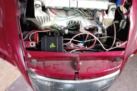Widok na instalację elektryczną motocykla, w tym moduł z zielonymi paskami, który może być kill switch motocykl.