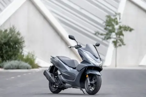 Szary skuter Honda PCX 125, gotowy na miejskie wyzwania. Niska awaryjność to jego atut.
