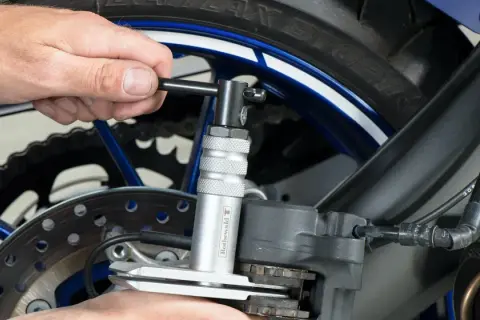 Narzędzie do ściskania tłoczków w zacisku hamulcowym motocykla, ułatwiające wymianę klocków hamulcowych.