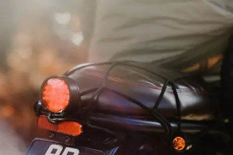 Tylne światło motocykla, czerwone i pomarańczowe, gotowe do sprawdzenia, jak sprawdzić czujnik stopu.