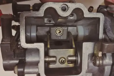Wnętrze gaźnika motocyklowego, gotowe do regeneracji. Widoczne elementy mechanizmu przepustnicy i dysz.