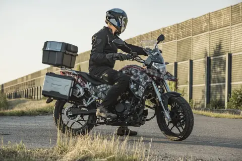 Motocyklista na Junak RX One 125 z kuframi, gotowy na zwiększenie mocy i przygodę.
