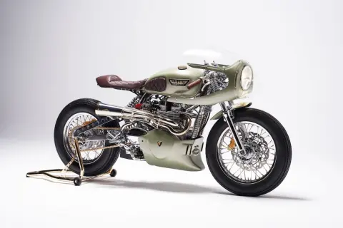 Stuning custom Triumph Thruxton 900 w kolorze oliwkowym, z brązową, pikowaną kanapą i chromowanymi detalami.