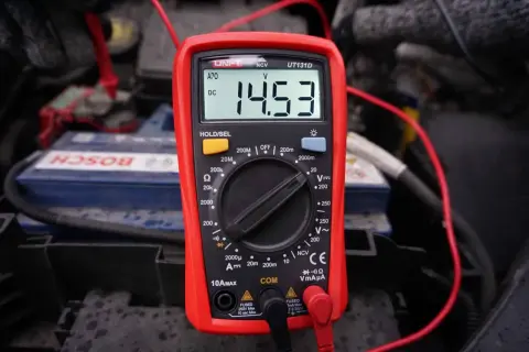 Multimetr pokazuje 14.53V, co jest kluczowe, jak sprawdzić alternator w motocyklu. Pomiar napięcia akumulatora podczas pracy silnika.