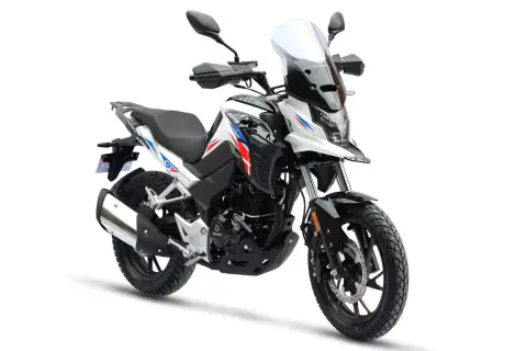 Biały motocykl turystyczny z niebieskimi i czerwonymi akcentami. Od ilu lat można robić prawo jazdy na motor 125? Od 16 roku życia.