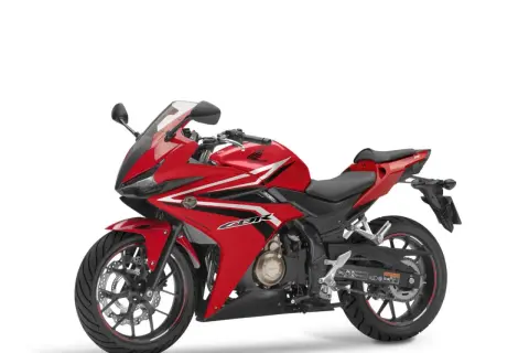 Czerwony motocykl sportowy Honda seria CBR z białymi i czarnymi akcentami, gotowy do jazdy.