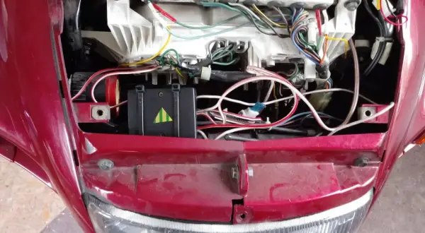 Widok na instalację elektryczną motocykla, w tym moduł z zielonymi paskami, który może być kill switch motocykl.