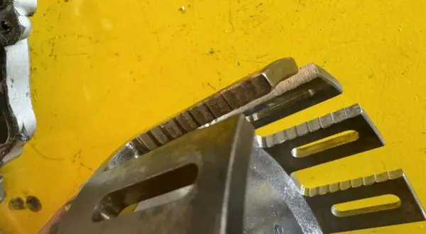 Metalowe elementy sprzęgła motocyklowego z ząbkowanymi krawędziami, gotowe do pracy.