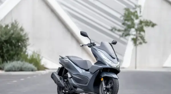 Szary skuter Honda PCX 125, gotowy na miejskie wyzwania. Niska awaryjność to jego atut.