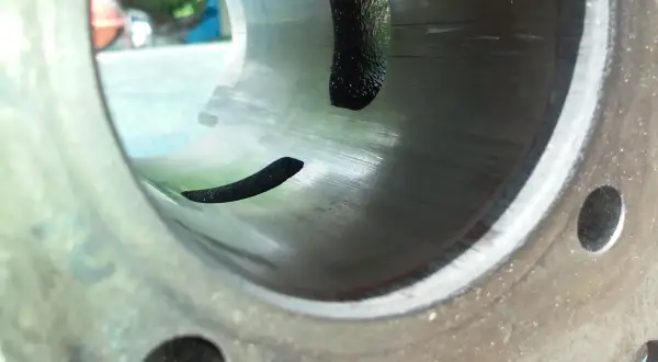 Wnętrze cylindra po docieraniu motocykla 125. Widać ślady honowania i fragmenty uszczelki.