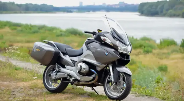 Szary motocykl BMW R 1200 RT z kuframi, gotowy na podróż. Wady i zalety tego modelu są dyskutowane przez pasjonatów.