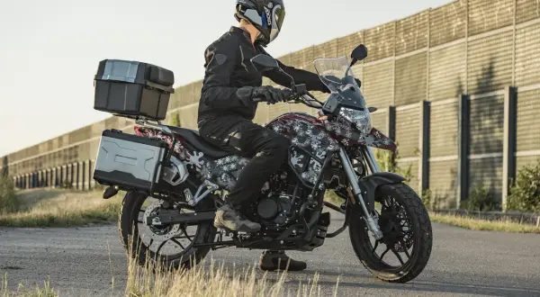 Motocyklista na Junak RX One 125 z kuframi, gotowy na zwiększenie mocy i przygodę.