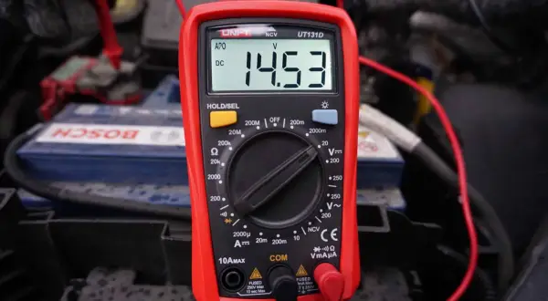 Multimetr pokazuje 14.53V, co jest kluczowe, jak sprawdzić alternator w motocyklu. Pomiar napięcia akumulatora podczas pracy silnika.