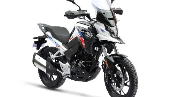 Biały motocykl turystyczny z niebieskimi i czerwonymi akcentami. Od ilu lat można robić prawo jazdy na motor 125? Od 16 roku życia.
