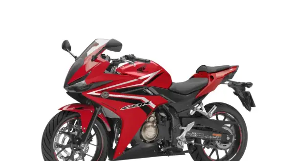 Czerwony motocykl sportowy Honda seria CBR z białymi i czarnymi akcentami, gotowy do jazdy.