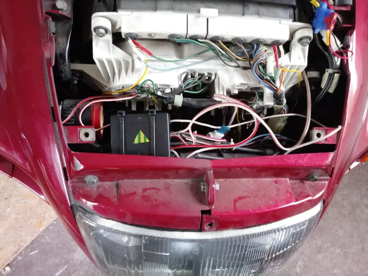 Widok na instalację elektryczną motocykla, w tym moduł z zielonymi paskami, który może być kill switch motocykl.