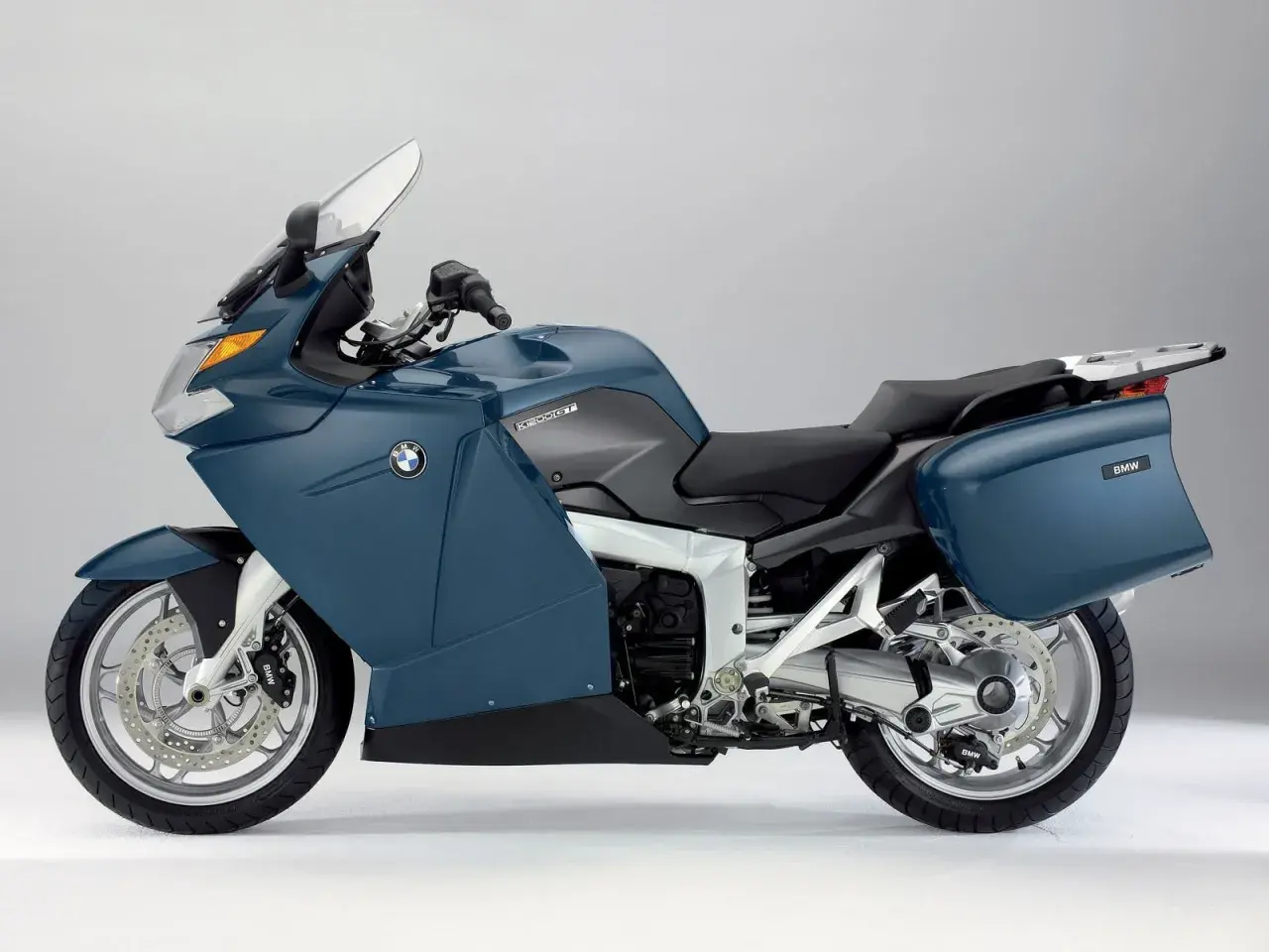 Niebieski motocykl BMW K 1200 GT, z kuframi. Choć piękny, jego wady mogą być znaczące dla niektórych kierowców.