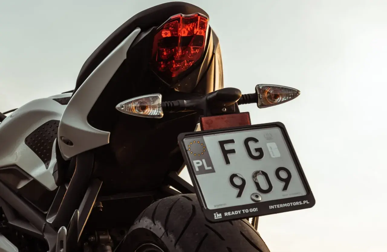 Tylna część motocykla z tablicą rejestracyjną FG 909. Dowiedz się, jak zarejestrować crossa, aby wyruszyć na przygodę!