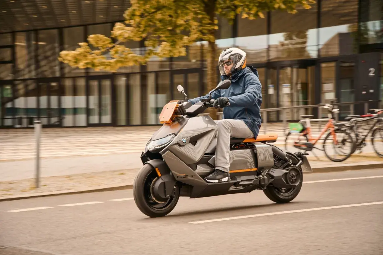 Mężczyzna w kasku jedzie na futurystycznym skuterze BMW CE04.