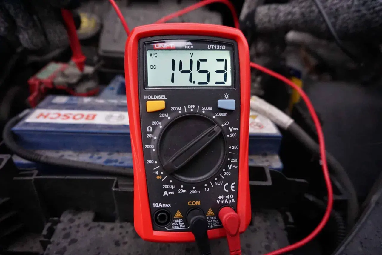 Multimetr pokazuje 14.53V, co jest kluczowe, jak sprawdzić alternator w motocyklu. Pomiar napięcia akumulatora podczas pracy silnika.