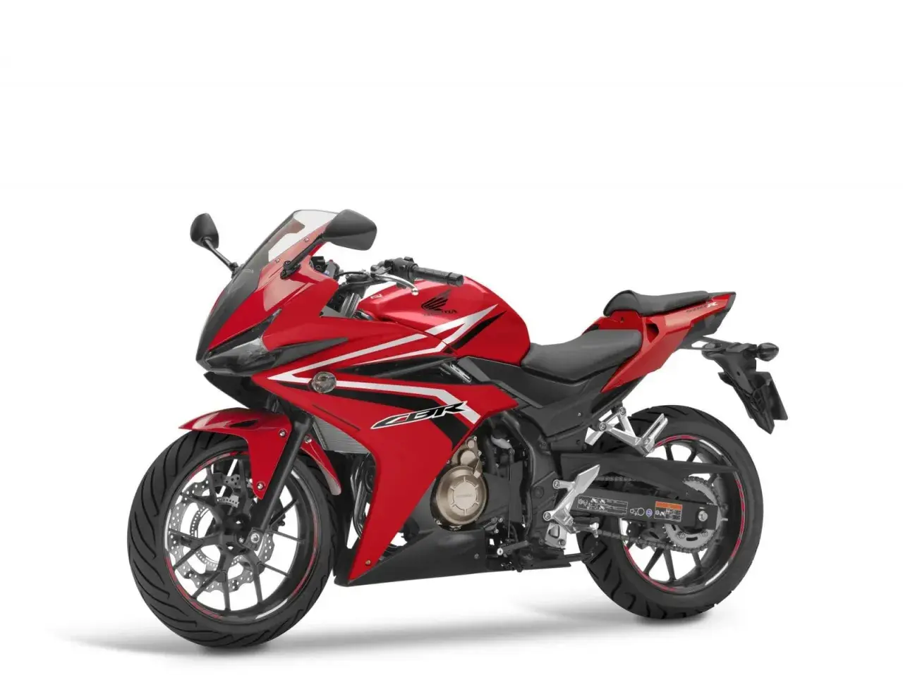 Czerwony motocykl sportowy Honda seria CBR z białymi i czarnymi akcentami, gotowy do jazdy.