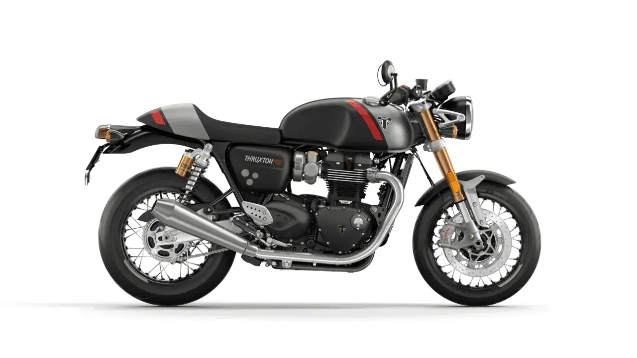 Stylowy motocykl Triumph Thruxton 900 w kolorze czarnym z czerwono-szarymi akcentami, gotowy na drogowe wyzwania.