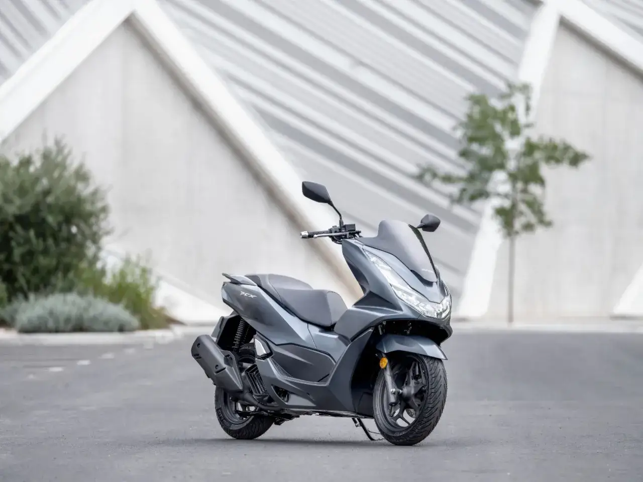 Szary skuter Honda PCX 125, gotowy na miejskie wyzwania. Niska awaryjność to jego mocna strona.