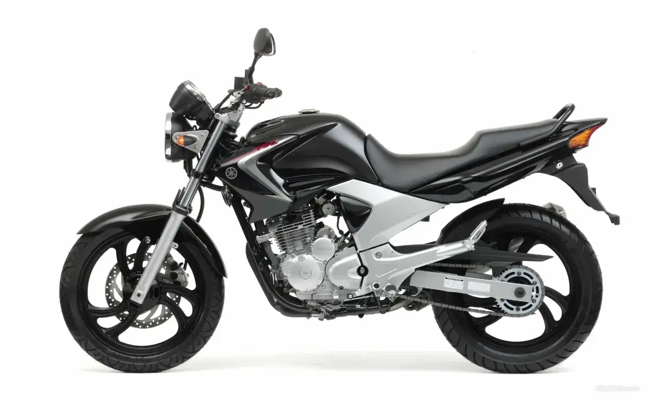 Czarny motocykl Yamaha YBR 250, gotowy do jazdy. Jego prędkość maksymalna pozwala na dynamiczne pokonywanie miejskich tras.