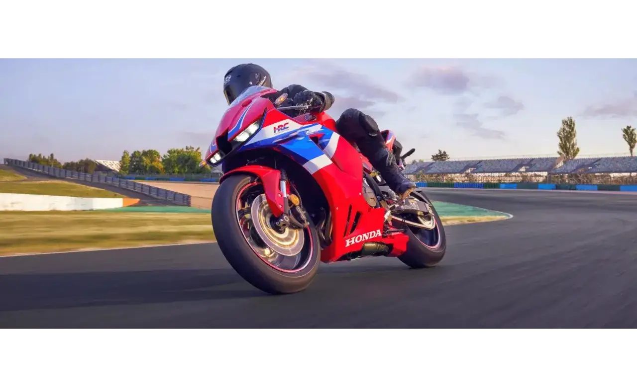 Motocyklista na torze ściga się na czerwonym motocyklu Honda seria CBR.