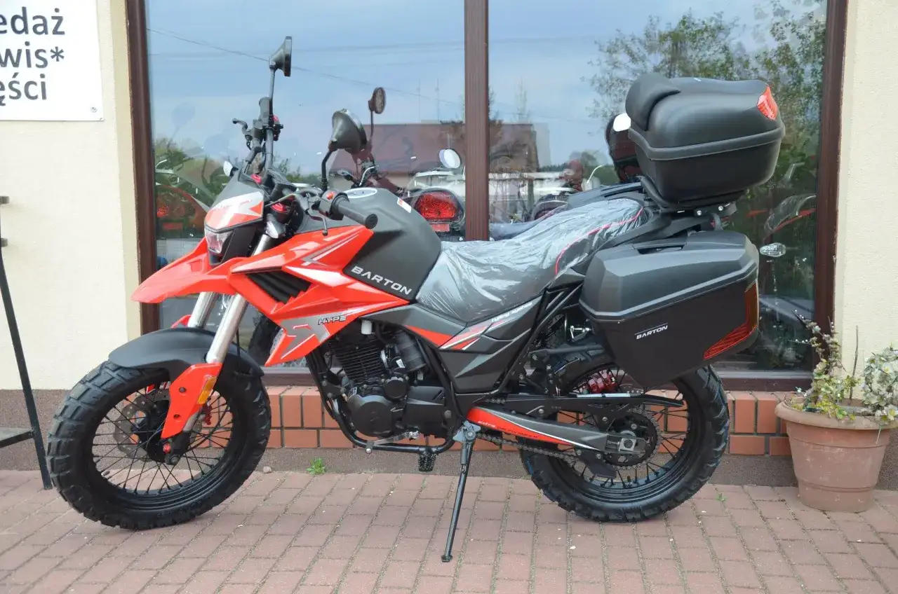 Czerwony motocykl Barton Hyper 125 z kuframi, gotowy na zwiększenie mocy i przygody.