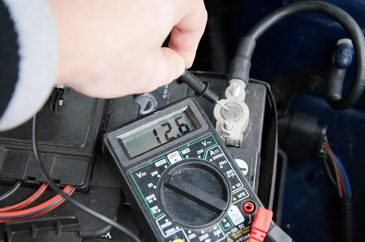 Pomiar napięcia akumulatora multimetrem. 12.6V to dobry wynik, ale zasiarczony akumulator objawy mogą być inne.