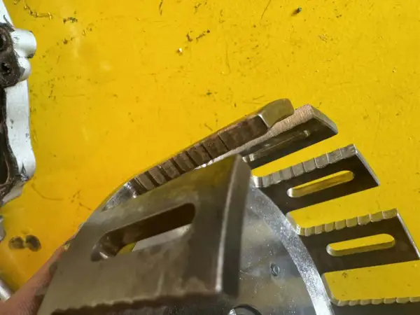 Metalowe elementy sprzęgła motocyklowego z ząbkowanymi krawędziami, gotowe do pracy.