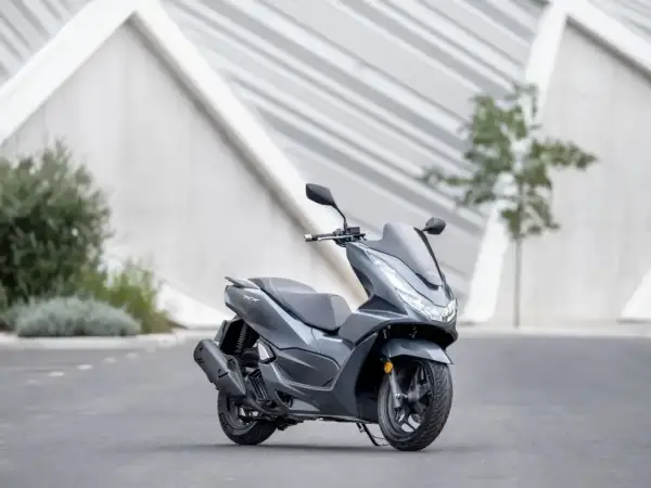 Szary skuter Honda PCX 125, gotowy na miejskie wyzwania. Niska awaryjność to jego atut.