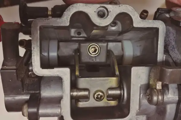 Wnętrze gaźnika motocyklowego, gotowe do regeneracji. Widoczne elementy mechanizmu przepustnicy i dysz.