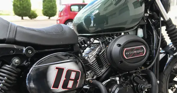 Część motocykla z siedzeniem, silnikiem i napisem "Grand Voyage 125". Numer "18" na błotniku.