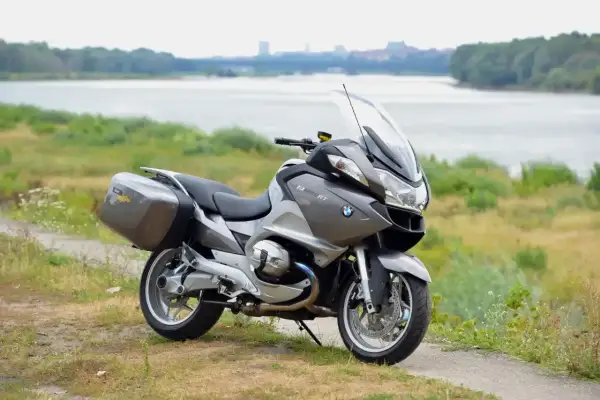Szary motocykl BMW R 1200 RT z kuframi, gotowy na podróż. Wady i zalety tego modelu są dyskutowane przez pasjonatów.
