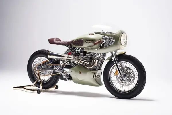 Stuning custom Triumph Thruxton 900 w kolorze oliwkowym, z brązową, pikowaną kanapą i chromowanymi detalami.