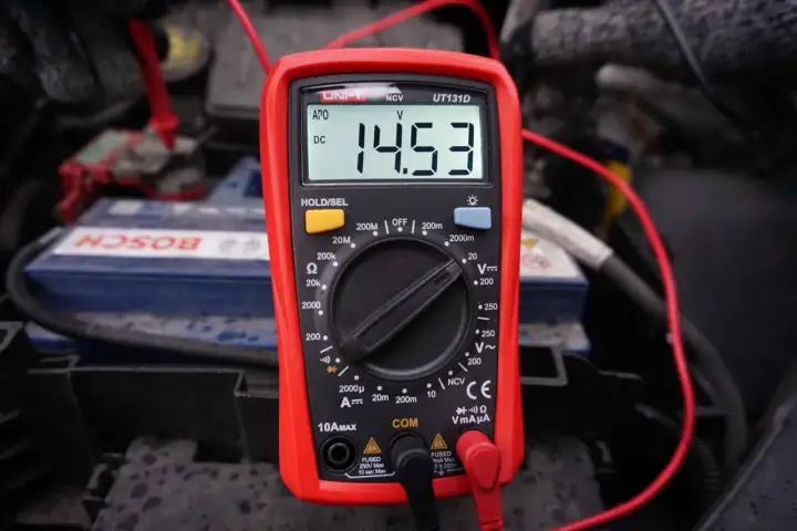 Multimetr pokazuje 14.53V, co jest kluczowe, jak sprawdzić alternator w motocyklu. Pomiar napięcia akumulatora podczas pracy silnika.